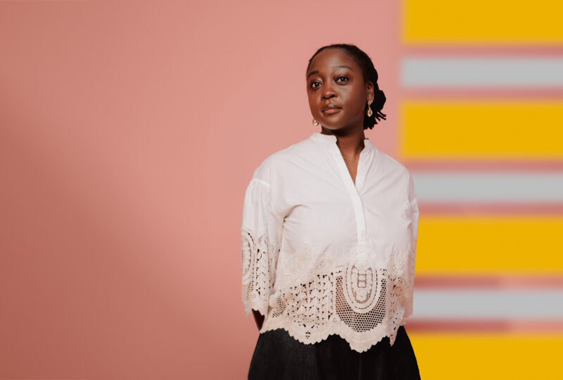 Cassie Kinoshi standing in front of a colourful background