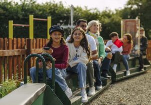 Family enjoying a mini train ride similar to the one popping up at SIM