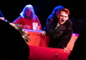 Actor dressed as a vampire in front of participants sat by table