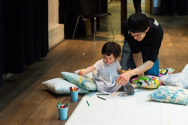 Adult and child drawing on the floor as part of the Family Weekend event