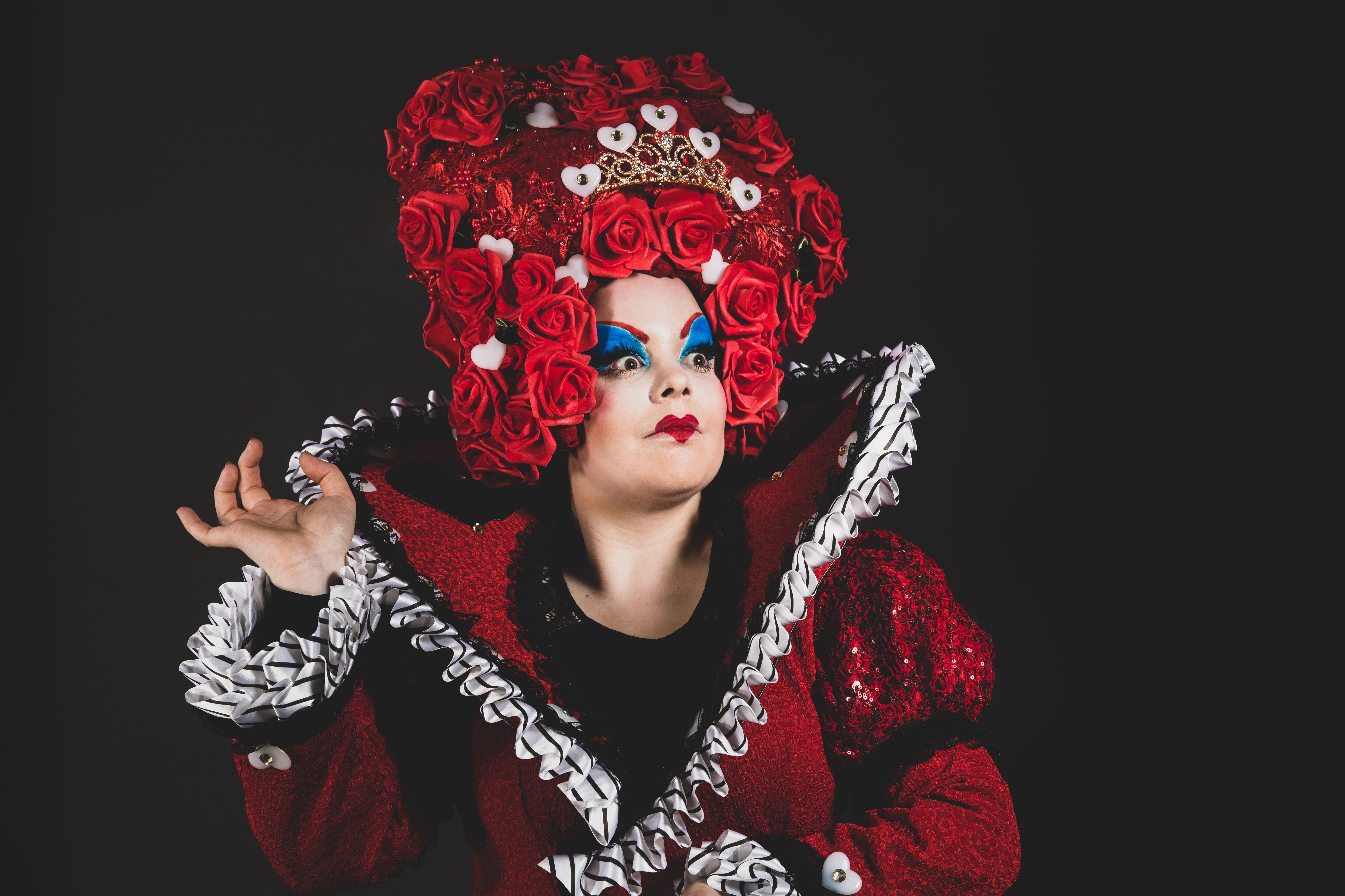 The Queen of Hearts from Alice in Wonderland at Waterside Arts. She is wearing a red dress with a wig of red roses.