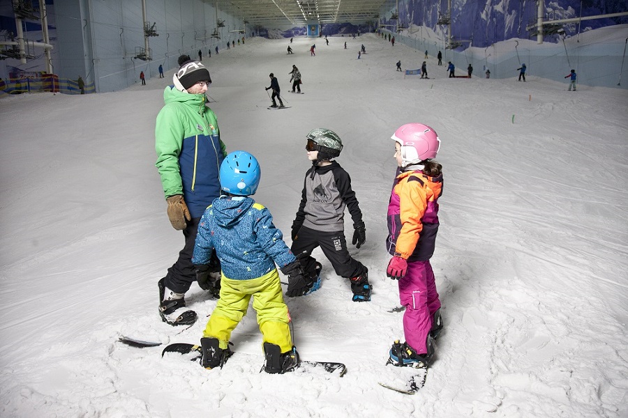 Three children with an instructor on the slope at Chill Factore