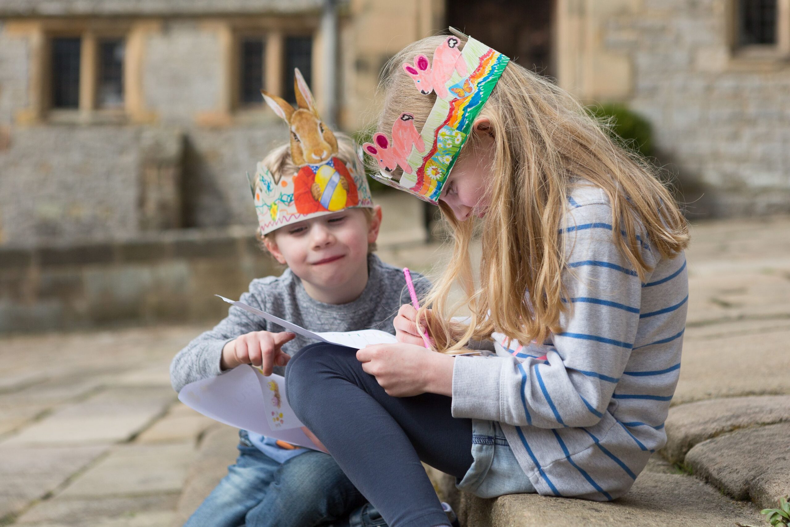 Two children wearing hats they've made - part of Easter at Haddon Hall